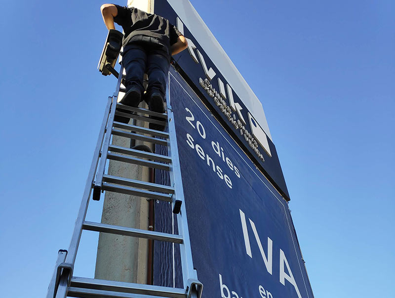instalación de lona de publicidad en altura mediante escalera