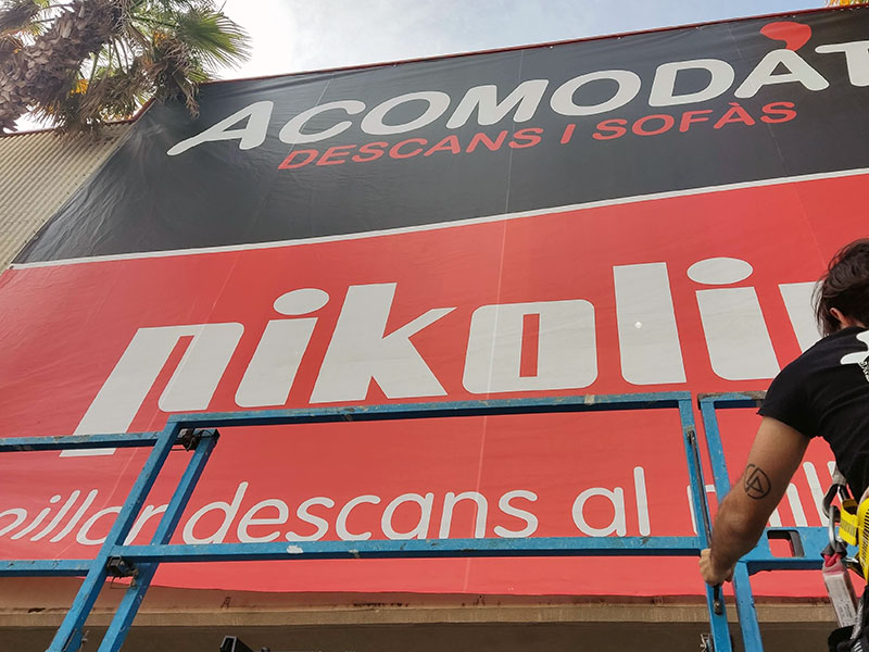instalación de lona publicitaria de gran formato en fachada