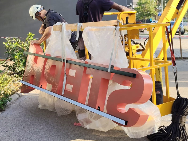 instalación de rótulo en altura con grúa