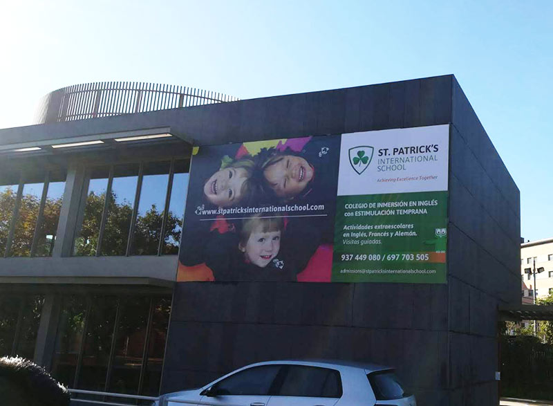 instalación de lona publicitaria en la fachada de colegio