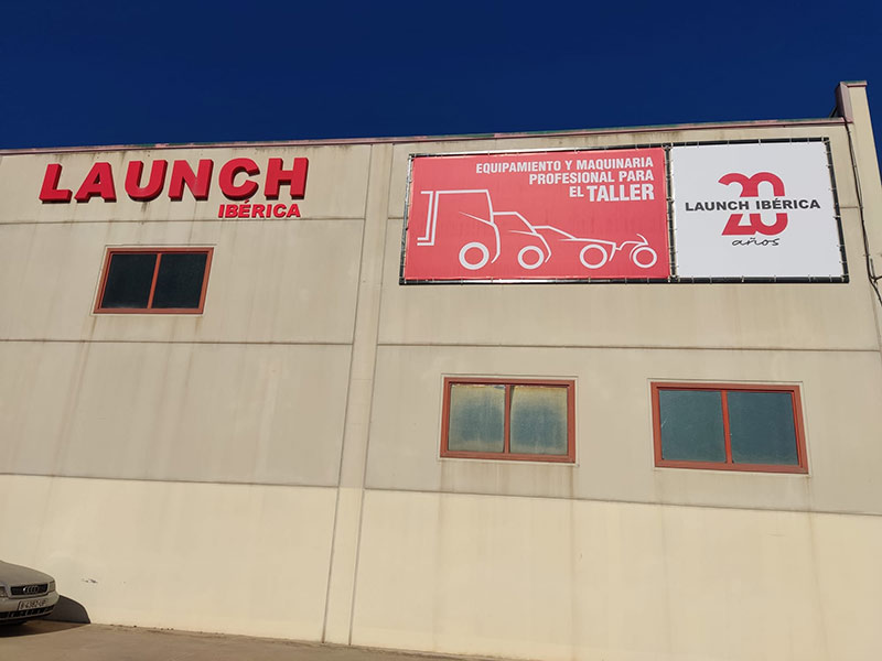 instalación de lona publicitaria con perímetro de tubo anclada a pared de nave industrial