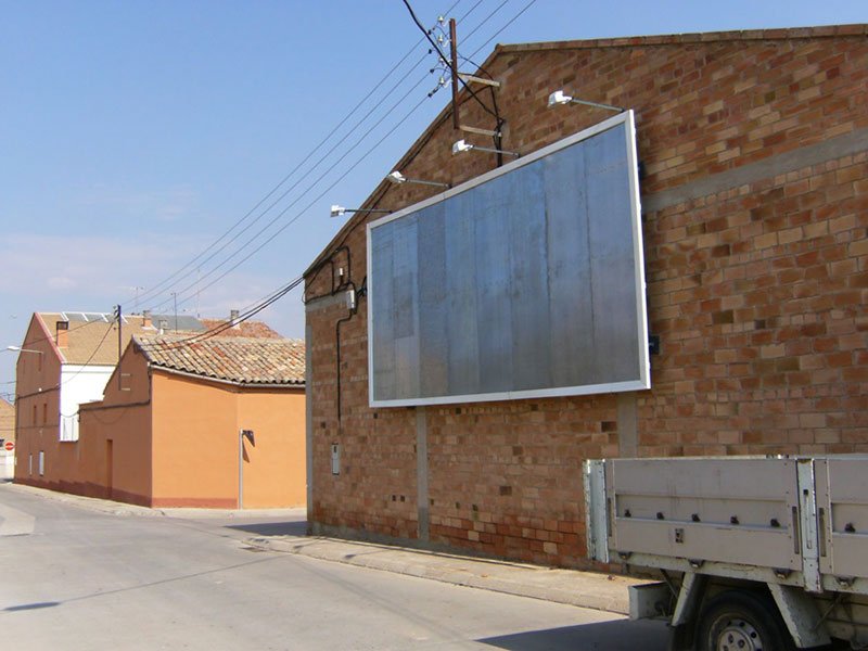instalación de valla publicitaria con focos en pared medianera